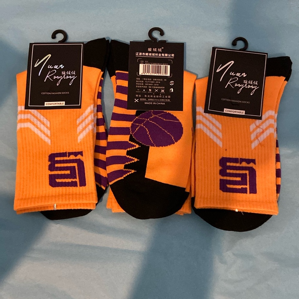 Three pair of purple and gold basketball socks